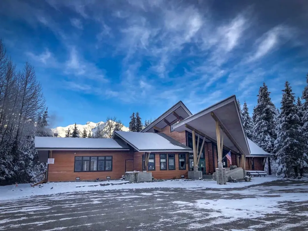 Girdwood Chapel exterior on a snowy day, with mountains behind the building